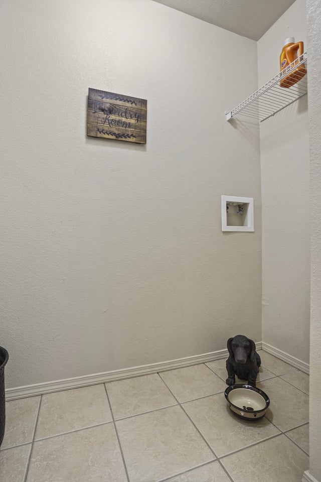 A dog is eating out of a bowl on the floor.