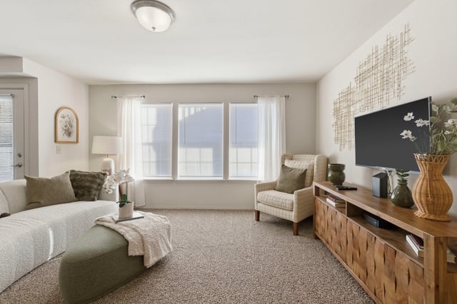 Living room with a couch, armchair, and TV.