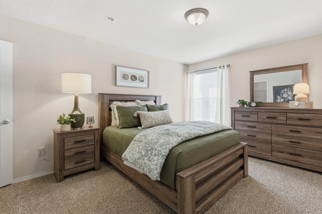 Cozy bedroom with a queen-size bed, nightstand, and dresser.