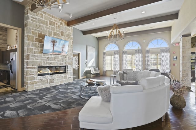 A living room with a stone fireplace and a white couch.