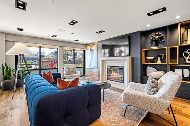 Modern apartment living room with a blue sofa, fireplace, and built-in shelving.