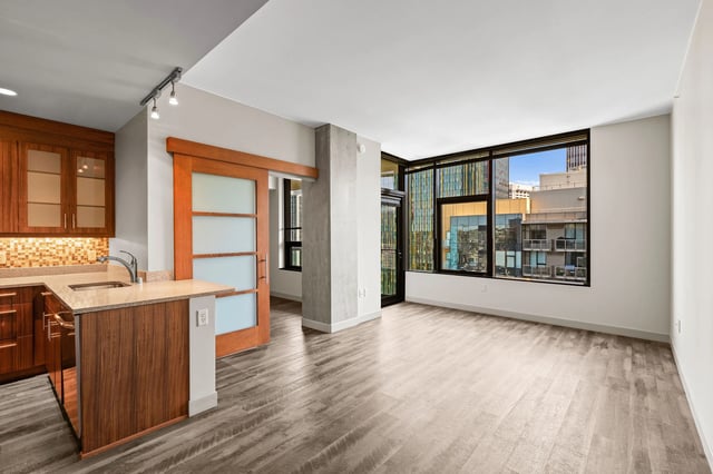Modern kitchen and living area with large windows and city views.