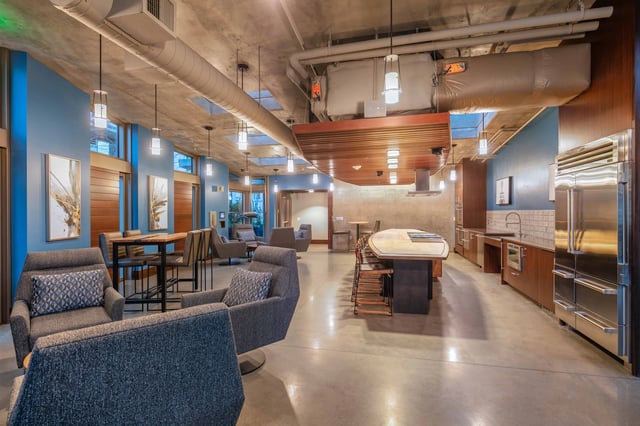 Stylish lounge area with modern seating, communal kitchen, and island.