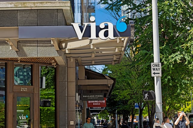 Via Apartments building exterior with signage and street view.