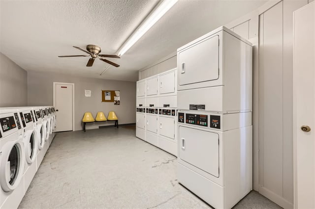 Laundry room with multiple washers and stacked dryers.