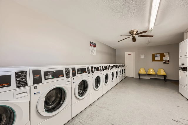 On-site laundry room with multiple washing machines and dryers, plus seating.
