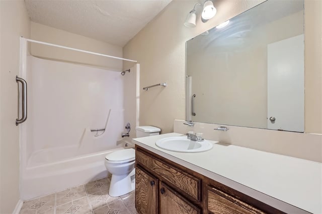 Bathroom with a toilet, sink, and shower/tub combo.