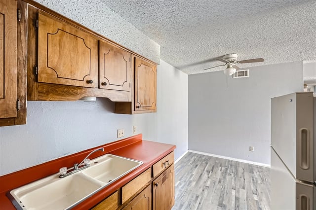 Kitchen with wooden cabinets and double sink.