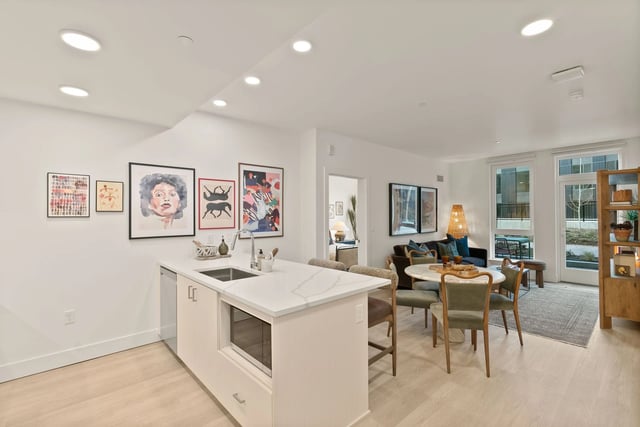 Open-concept kitchen and living area with dining table and sofa.