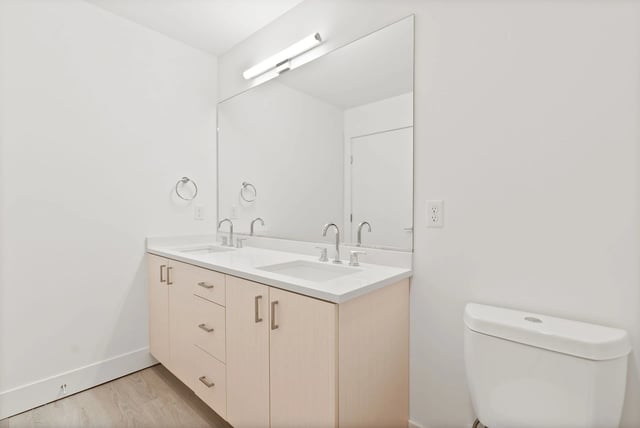 Modern bathroom with double-sink vanity, large mirror, and toilet.