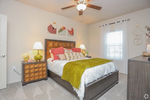 Primary bedroom with a king-size bed, plush bedding, and modern nightstands.