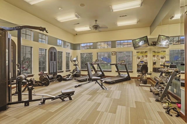 Modern fitness center with treadmills, weight machines, and free weights.