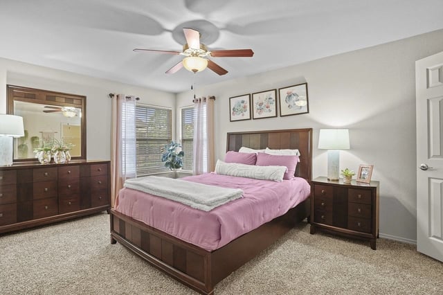 A primary bedroom with a king-size bed, dresser, and nightstand.