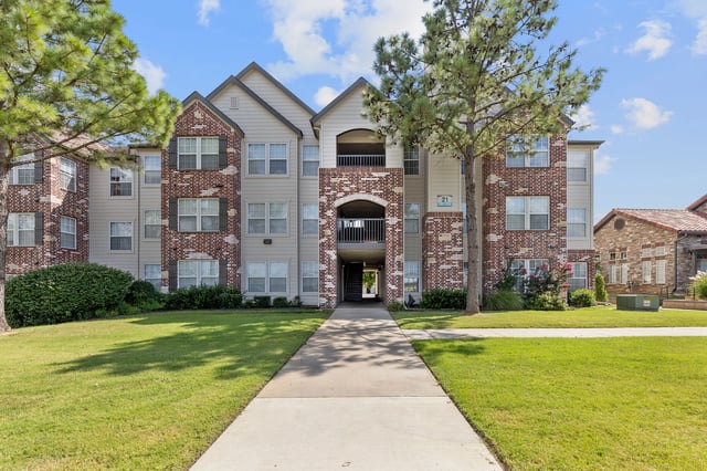 Exterior of apartment building with a walkway leading to the entrance.