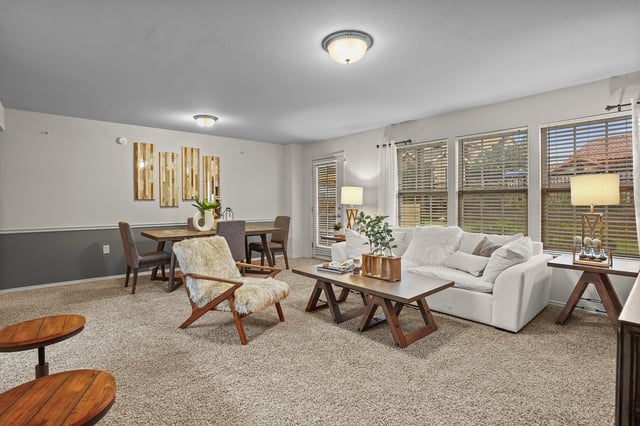 Cozy living and dining area with plush sofa, accent chair, and dining table.
