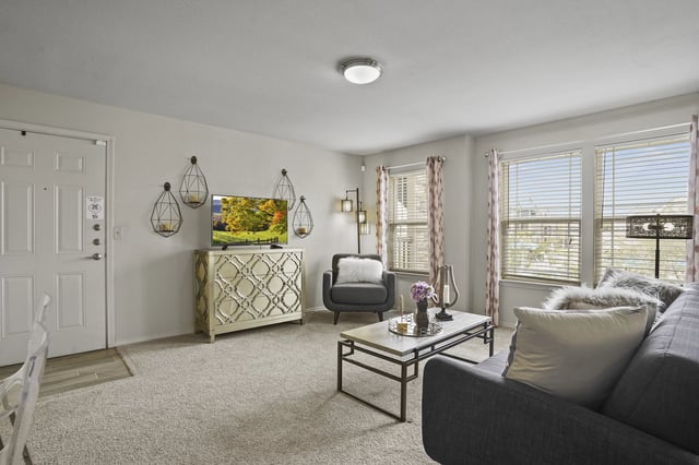Spacious living room with a sofa, armchair, coffee table, and TV.