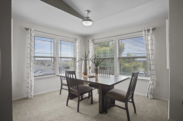 A dining room with a table and chairs.
