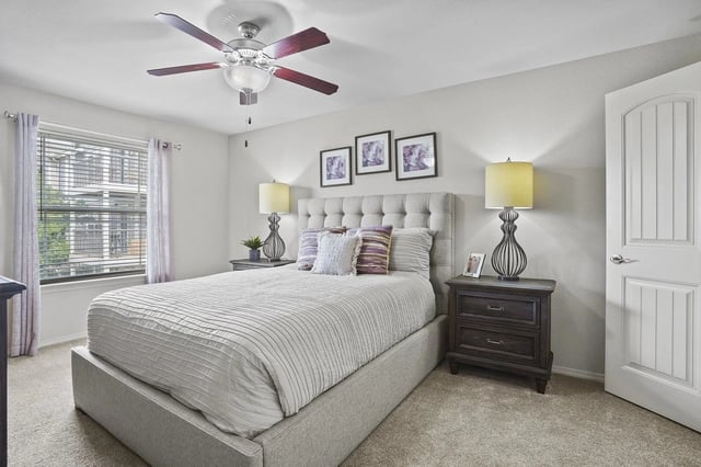 Spacious bedroom with a large bed, nightstands, and a ceiling fan.