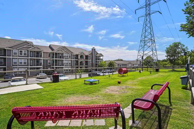 Apartment community dog park with agility equipment and seating.
