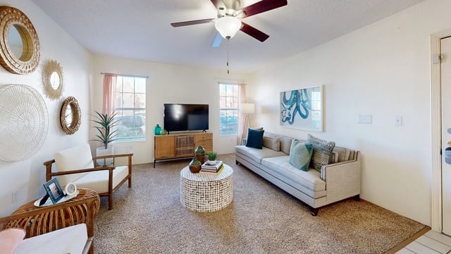 Living room with a sofa, armchair, coffee table, entertainment center, and wall decor.