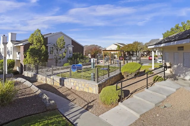 Exterior view of a multifamily community courtyard with landscaped paths, stairs, and railings.