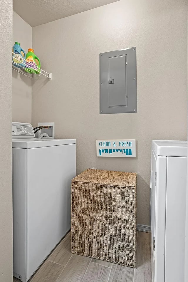 In-unit laundry area with washer, dryer, storage basket, and detergent.