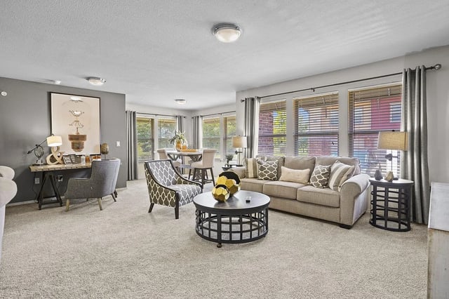 Living room with a sofa, chairs, coffee table, and dining area.
