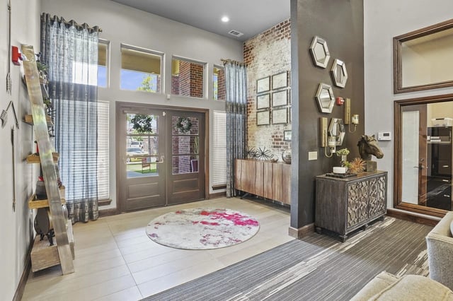 Interior view of a multifamily property's grand entrance with double doors, large windows, and decorative elements.