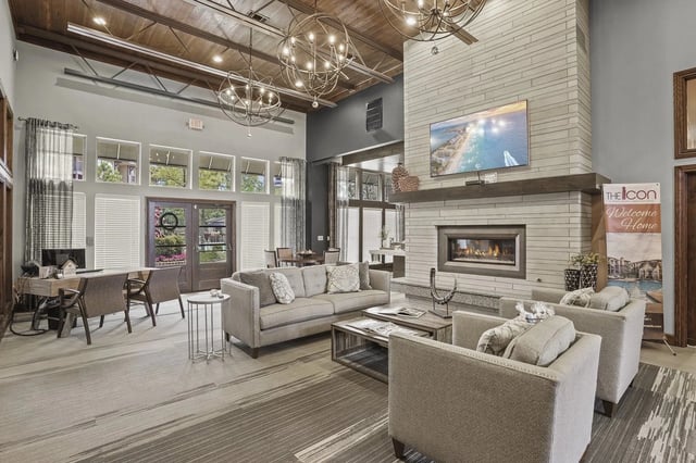 Modern lounge area with a fireplace, comfortable seating, and large windows.