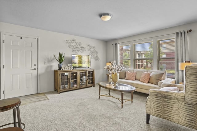 Living room with a couch, armchair, coffee table, and TV stand.