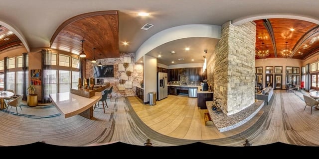 Modern communal kitchen and lounge area with stone fireplace and stylish seating.