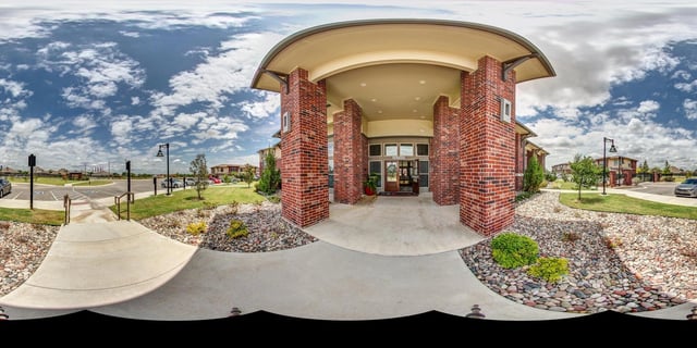 Entrance to apartment buildings with brick pillars and a covered walkway.