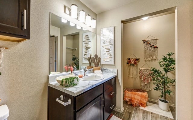 Bathroom vanity with double sink, marble countertop, and a mirror in an apartment.