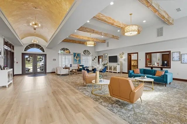 Spacious community lobby with modern seating, wood beams, and large arched windows.