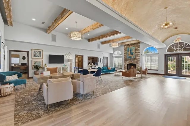 Spacious residential clubhouse lobby with seating and large arched windows.