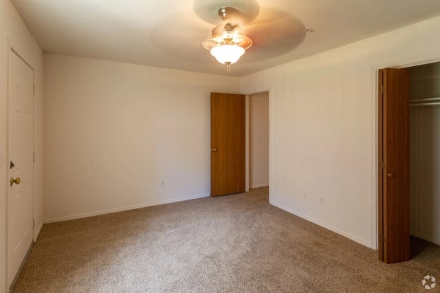 Empty bedroom with a ceiling fan and closet