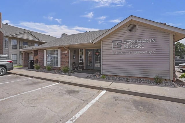 Exterior view of the Persimmon Square leasing office with parking lot.