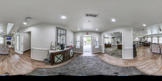 Interior view of apartment building lobby with coffee station and seating area.