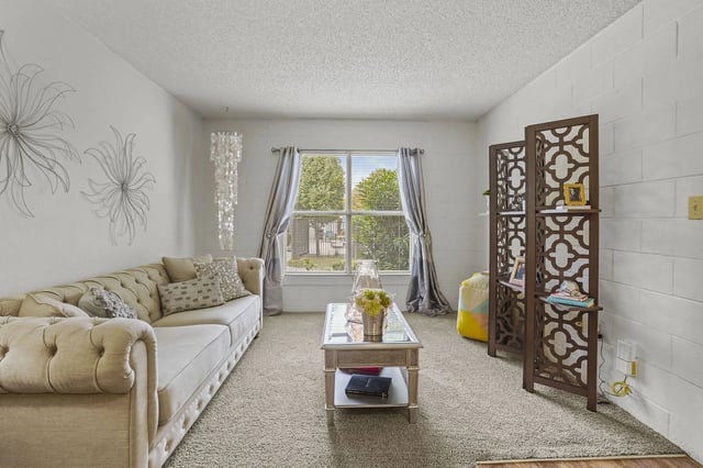 Living room with a plush couch, decorative wall art, and a coffee table.