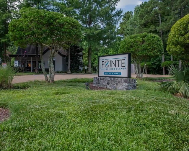 Exterior view of The Pointe of Ridgeland entrance sign amid trees and landscaping.