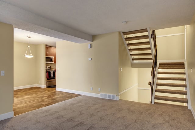 Living room with stairs and kitchen view