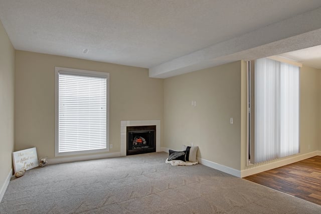 Living room with a fireplace and large window.