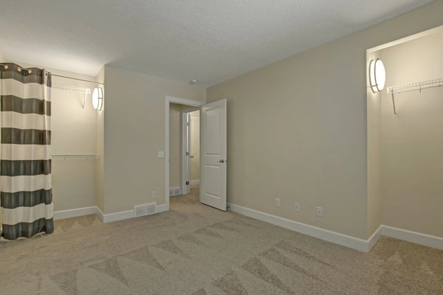 Bedroom with a closet area and an en suite bathroom.