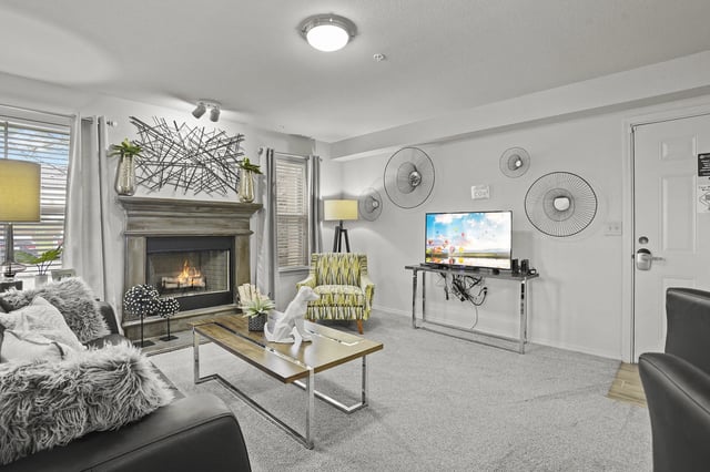 Living room with a fireplace, sofa, armchair, and TV.