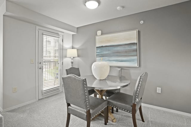 A dining room with a table and chairs.