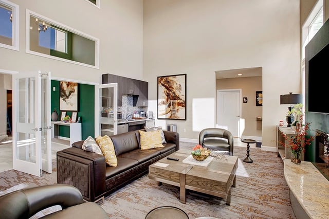 Spacious living area with a large brown leather sofa, coffee table, and fireplace.