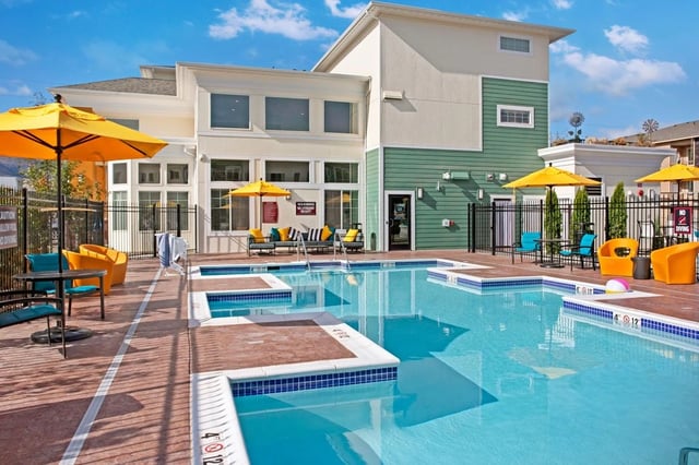 Outdoor swimming pool with lounge chairs and umbrellas.