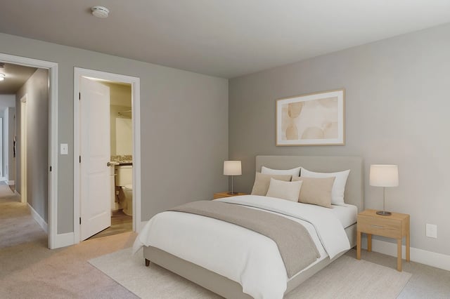 Bedroom with a queen-size bed, nightstands, and a doorway to the bathroom.