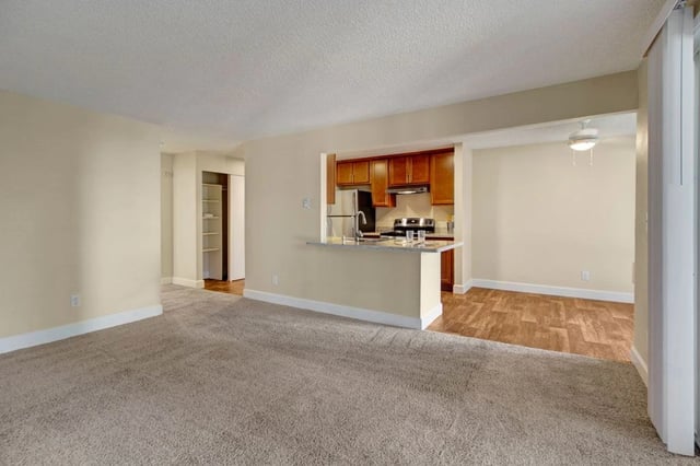 Living room and kitchen area with breakfast bar in an apartment