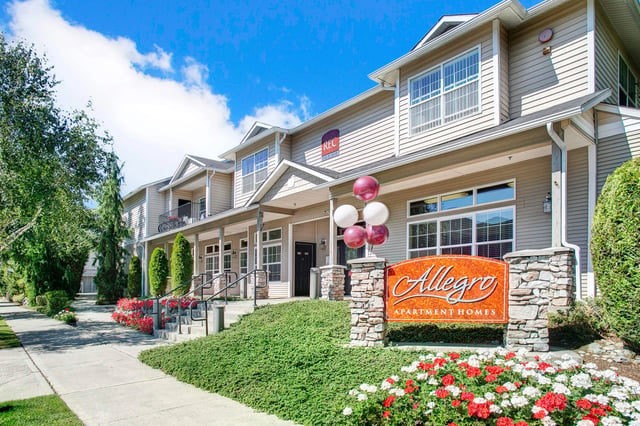 Allegro Apartment Homes entrance sign with balloons and landscaping.